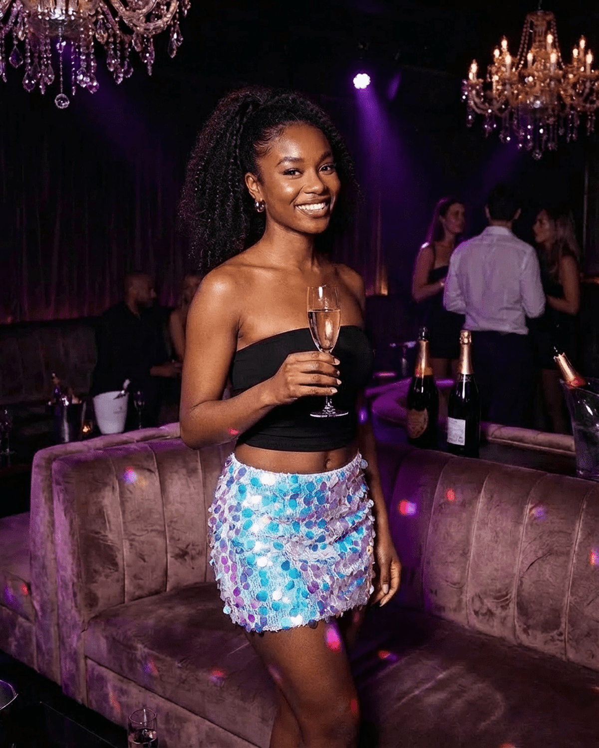 Celeste Mini Skirt by RAMBLION worn at a party, showcasing blue iridescent sequins and a bodycon silhouette.