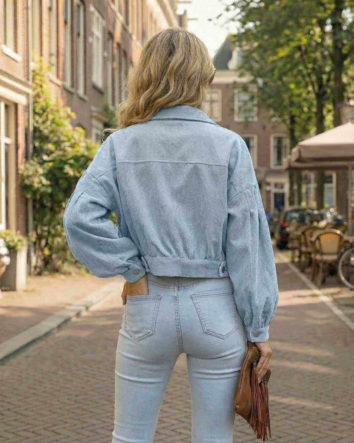 Back view of a woman in Arla Jacket, a blue cropped corduroy jacket, perfect for stylish fall layering.