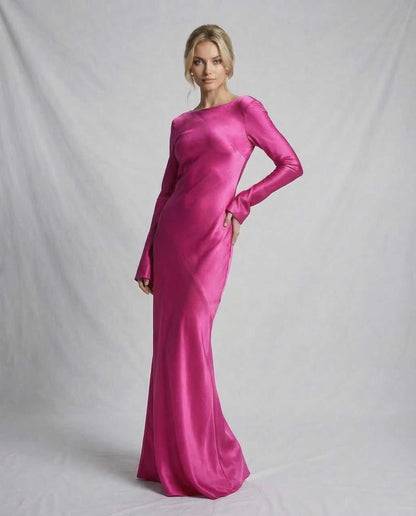 Bess Maxi Dress in vibrant pink satin, featuring long sleeves and a graceful silhouette for elegant occasions.