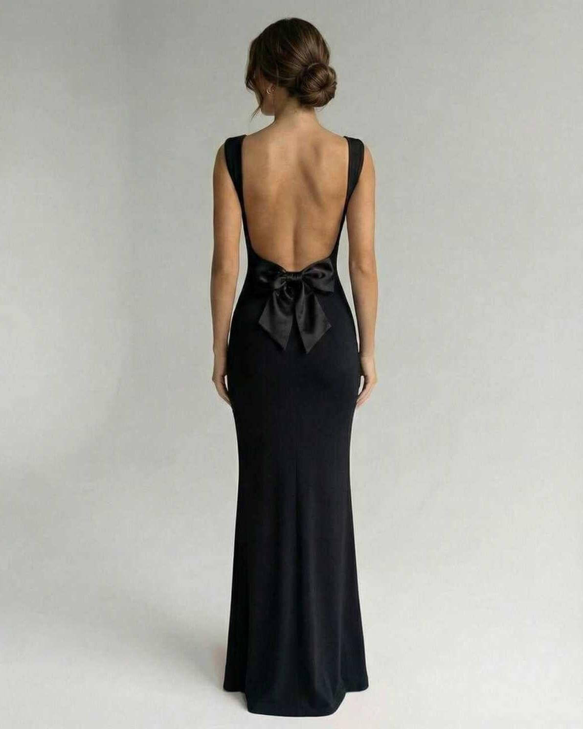 Biot Maxi Dress showcasing a backless design with a bow, elegant black satin perfect for formal occasions by RAMBLION.