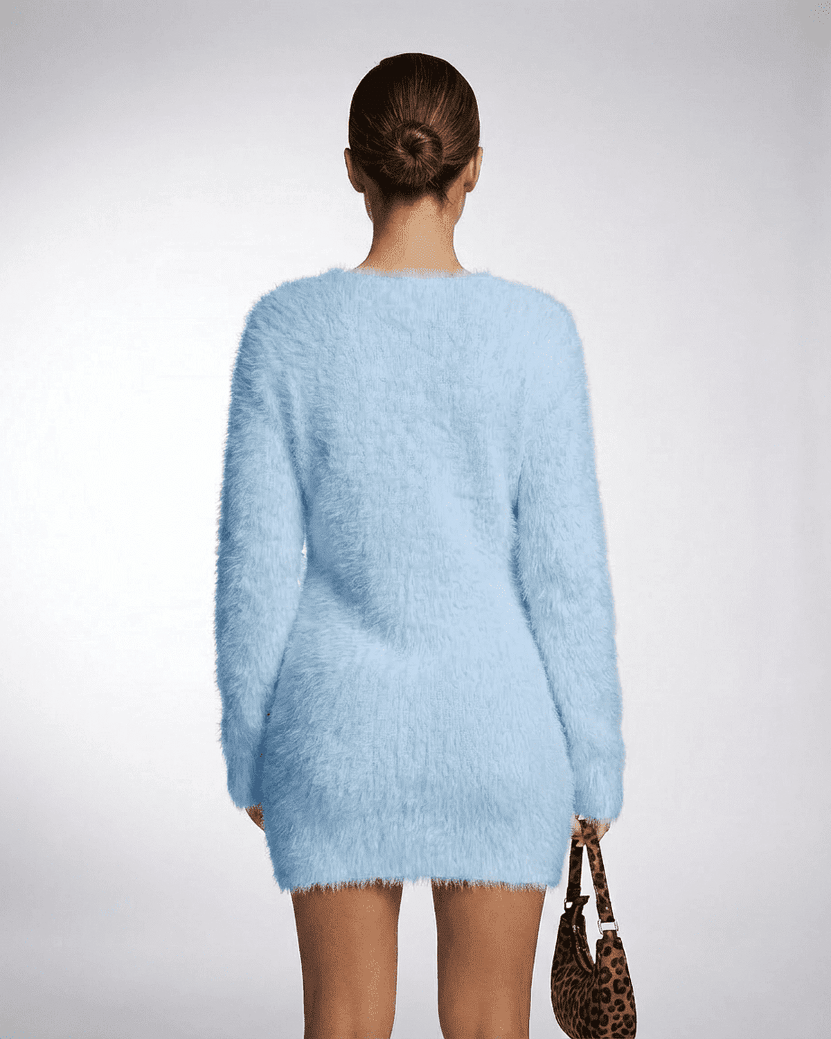 Model wearing the Celeste Sweater in sky blue, showcasing its fuzzy plush knit texture and V-neck design.