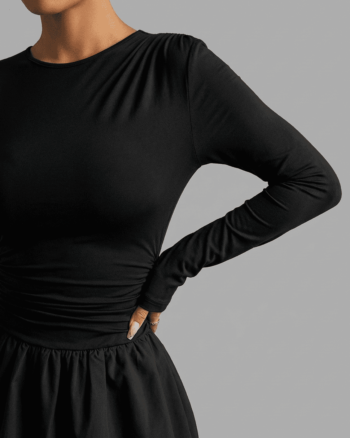Detail of the Elara Mini Dress by RAMBLION, featuring fitted long sleeves and a cinched waist design.