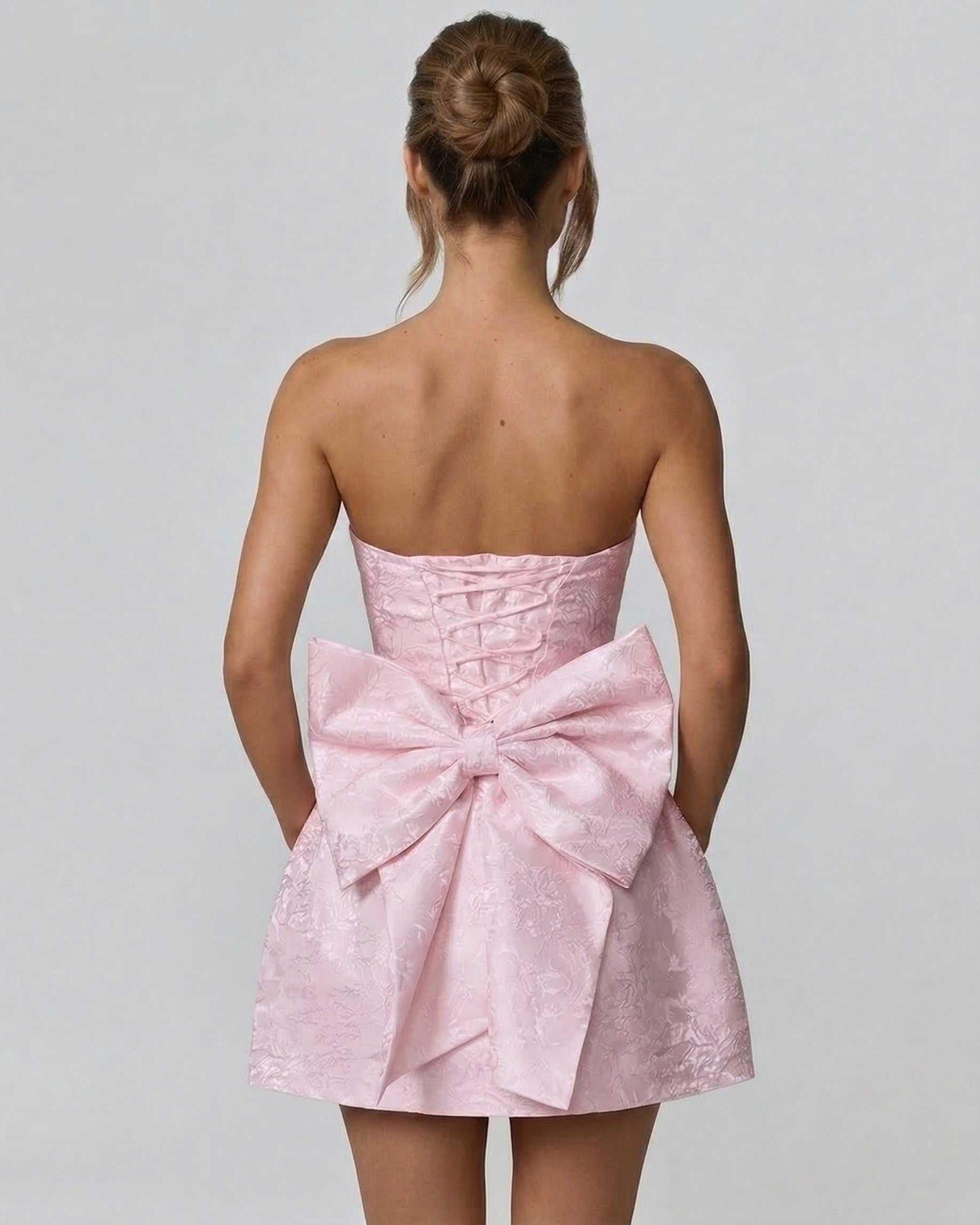 Gila Mini Dress by RAMBLION, pink strapless mini dress with oversized back bow, perfect for summer occasions.