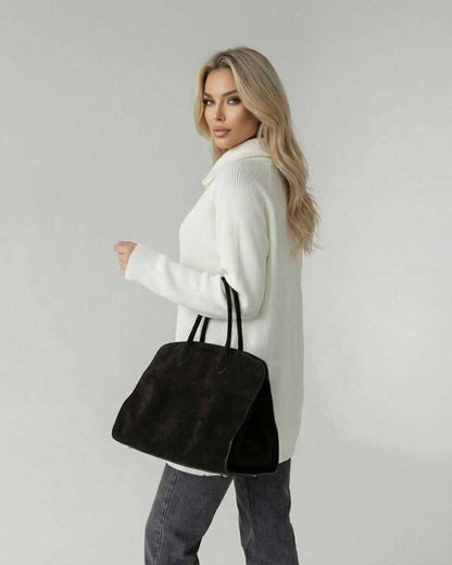 Indie Sweater worn by a woman with long hair, featuring a relaxed fit, paired with a stylish black handbag.
