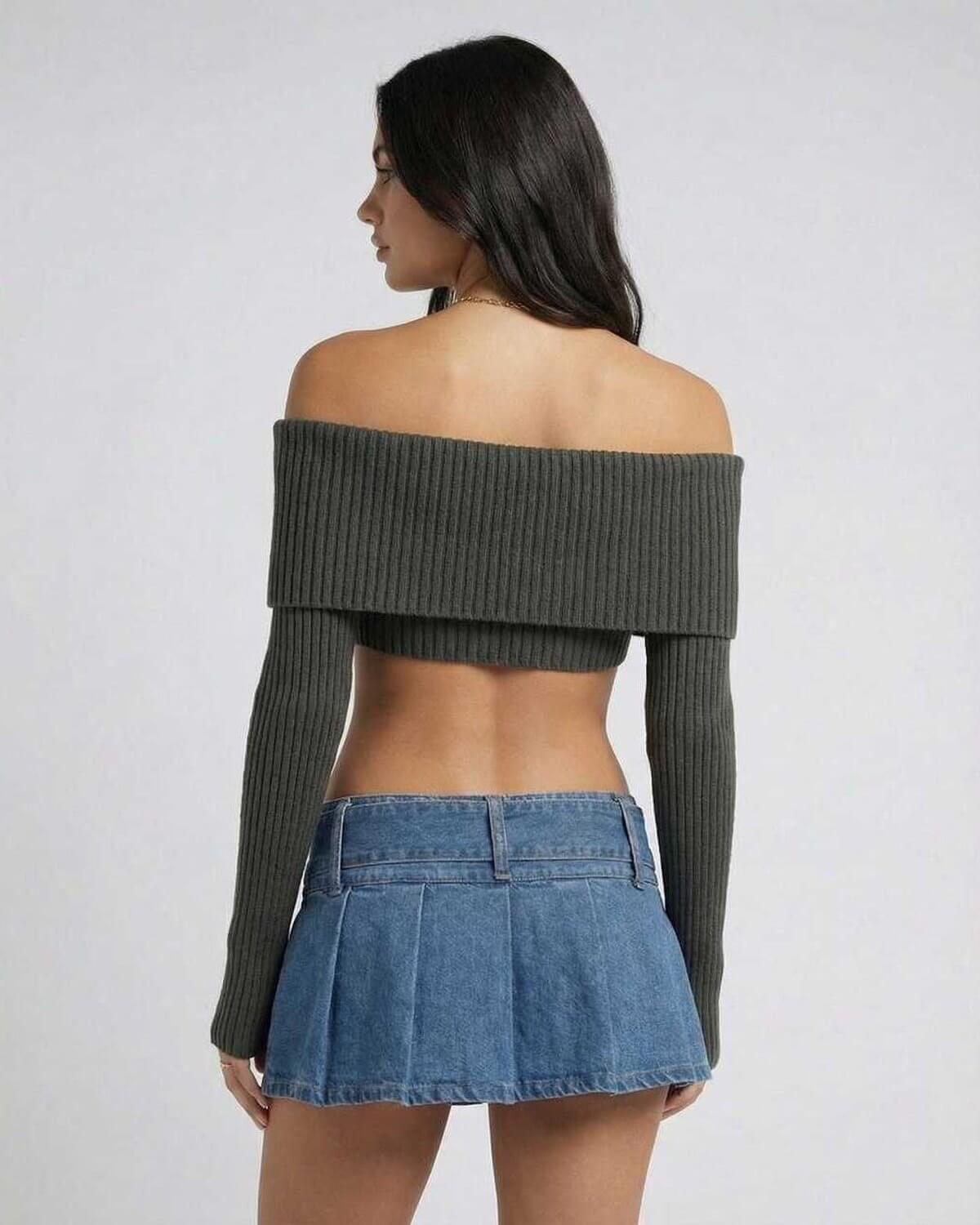 Back view of a model in the Kobe Top, a green ribbed off-shoulder crop top, paired with a denim skirt, perfect for autumn style.