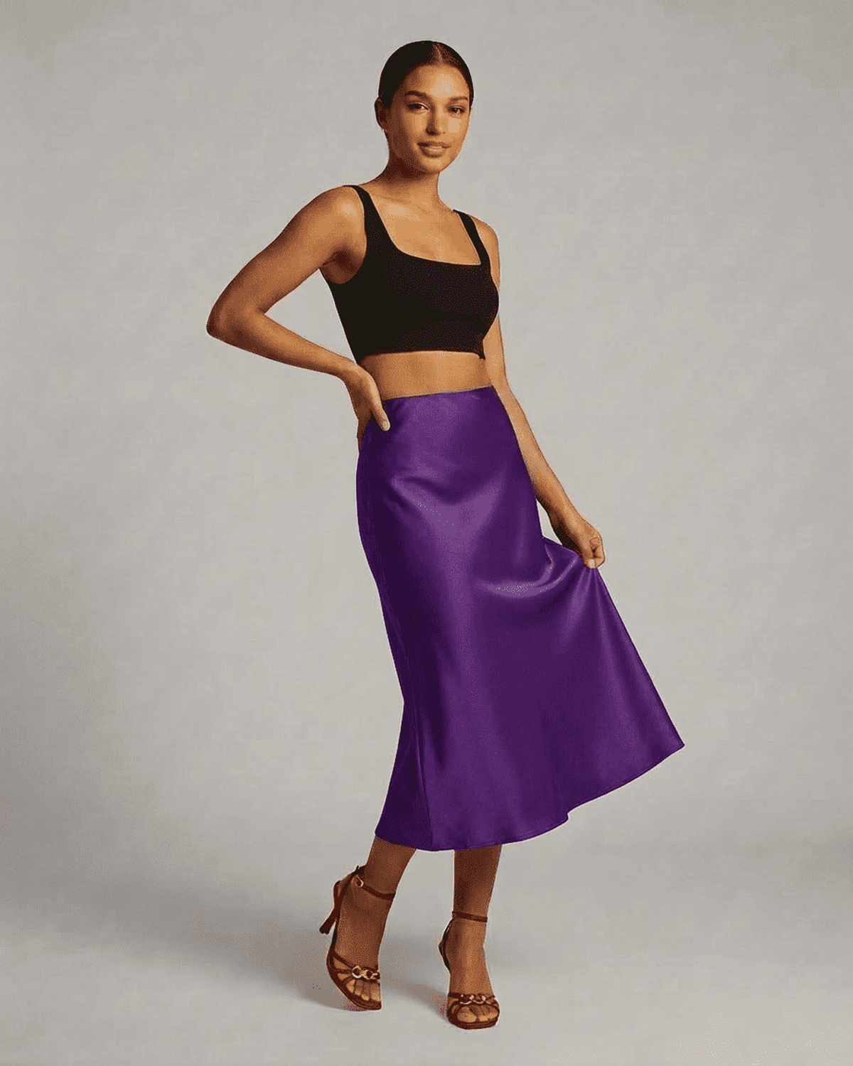 Model wearing the Amethyst Midi Skirt by RAMBLION, showcasing the elegant satin mermaid design in vibrant purple.