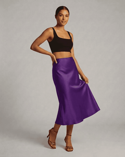 Model wearing the Amethyst Midi Skirt by RAMBLION, showcasing the elegant satin mermaid design in vibrant purple.