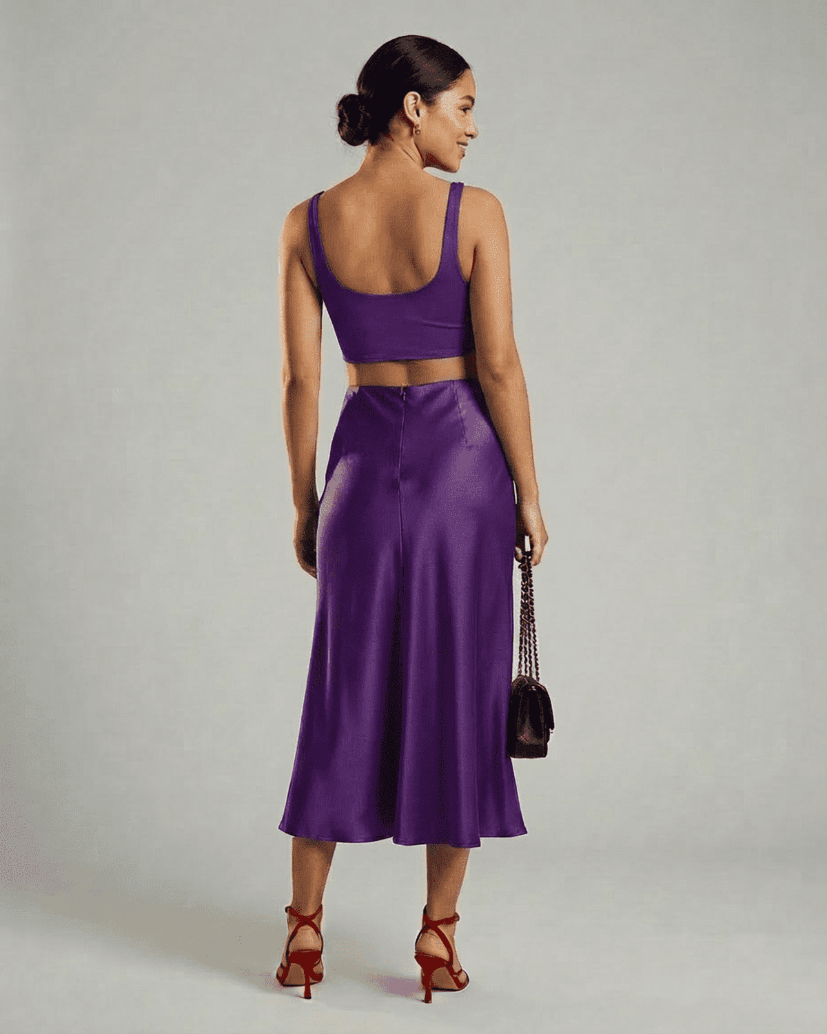 Back view of a model wearing the RAMBLION Amethyst Midi Skirt paired with a crop top.