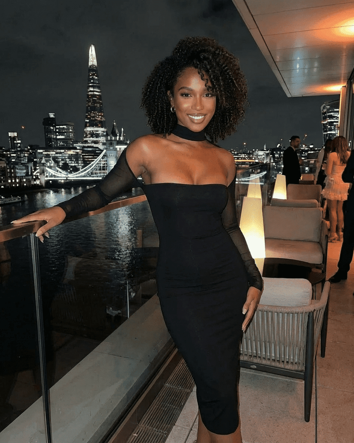 Arden Midi Dress by RAMBLION showcased in a chic evening setting with city skyline background.
