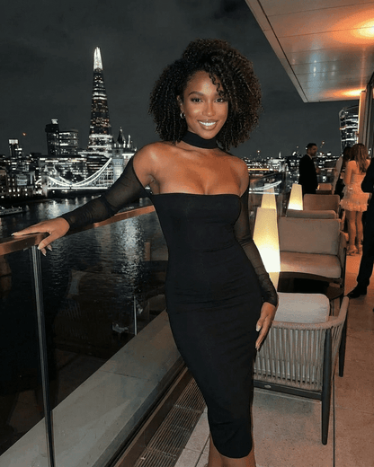 Arden Midi Dress by RAMBLION showcased in a chic evening setting with city skyline background.