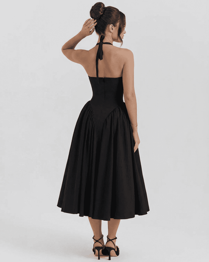 Back view of a woman in a black Celeste Midi Dress by RAMBLION featuring a halter neck design.