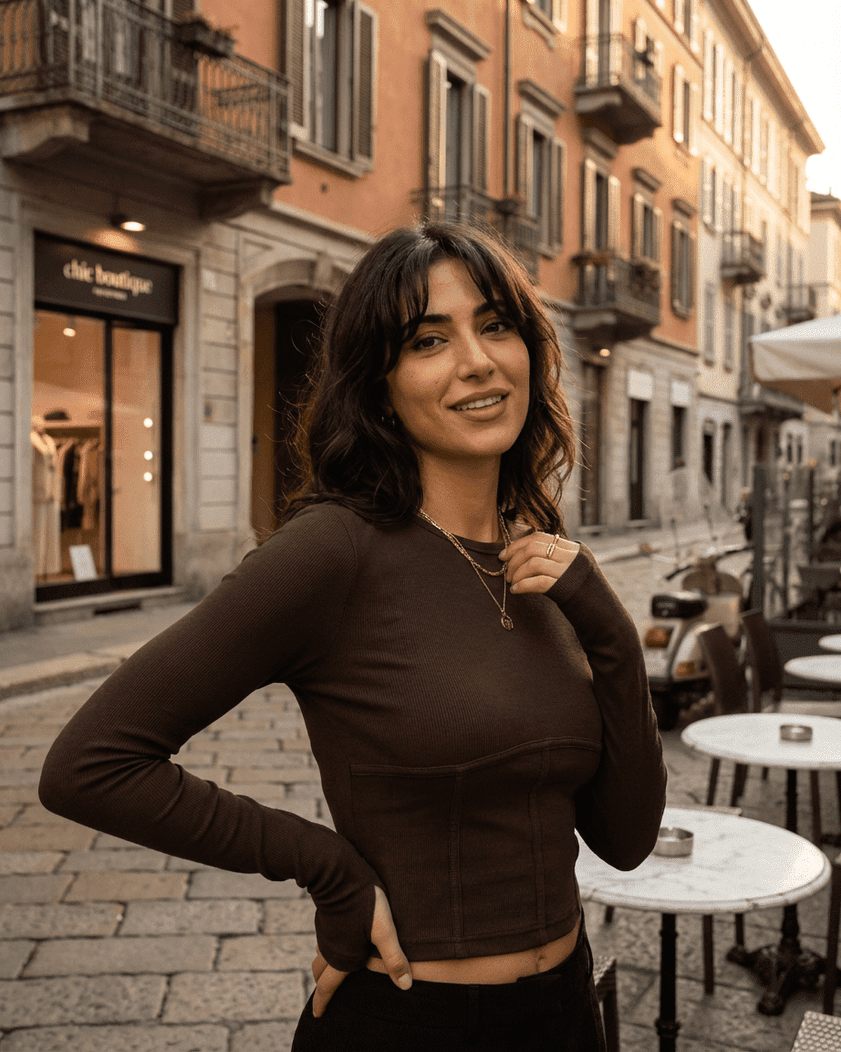 Woman wearing the Cocoa Corset Top by RAMBLION, showcasing a stylish long sleeve jersey crop in an urban setting.