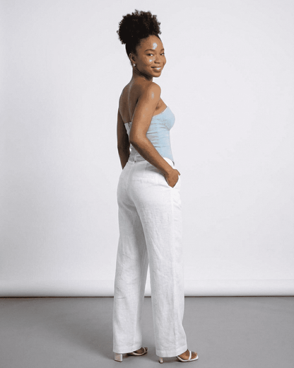 Denali Corset Top by RAMBLION, showcasing a woman in a faux denim bustier with stylish white linen pants.