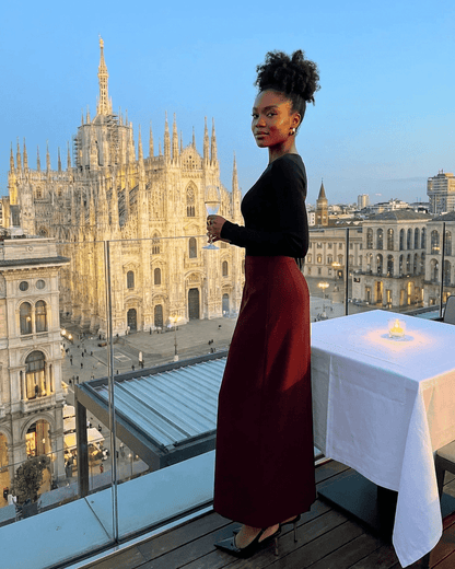 Merlot Maxi Skirt by RAMBLION worn by a woman with a stunning cityscape view in Milan.