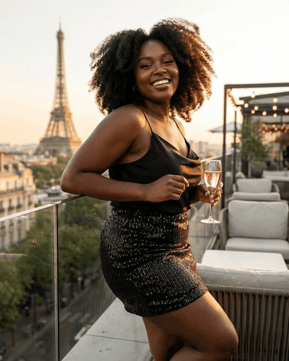 Woman enjoying a sunset in Paris wearing the Noiré Mini Skirt by RAMBLION with a glass of champagne.
