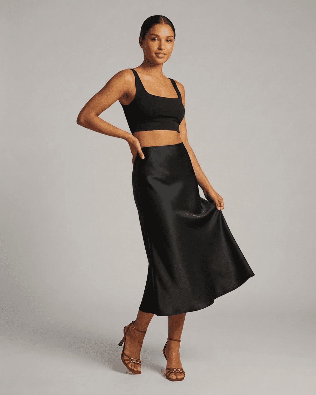 Noirelle Midi Skirt from RAMBLION displayed on a model, showcasing the sleek satin mermaid design in classic black.