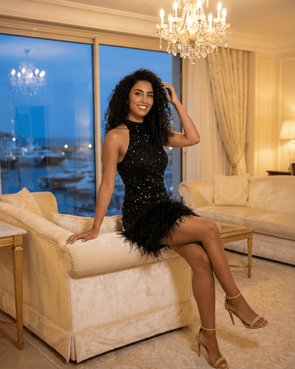 Onyx Mini Dress by RAMBLION, featuring a black sequin bodycon design and fuzzy hem, showcased in an elegant indoor setting.