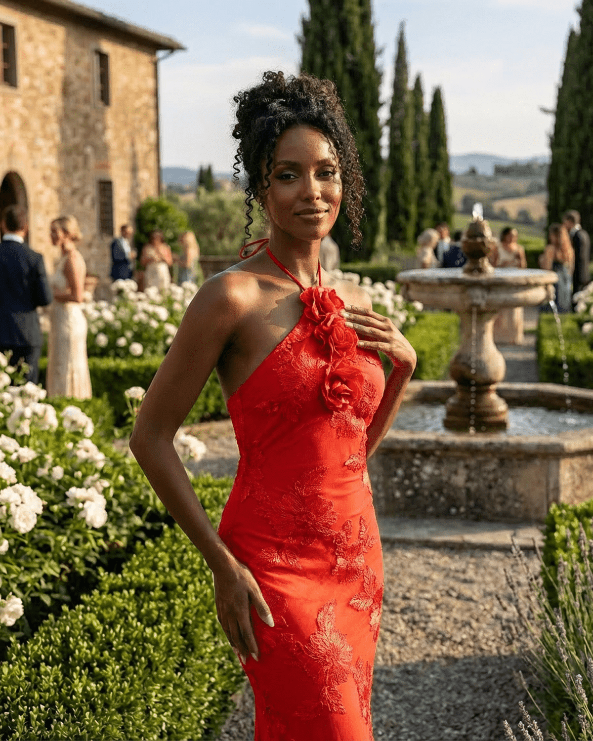 Rosalia Maxi Dress by RAMBLION, displaying a model in a bold red halter neck dress with 3D floral details in a scenic garden.