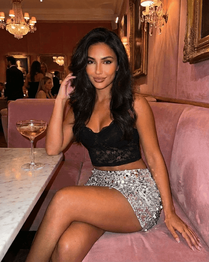 Model wearing Sterling Mini Skirt by RAMBLION with silver sequin hem, posed elegantly at a chic venue.