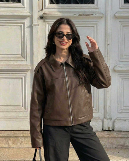 Woman wearing Lina Jacket by RAMBLION, rich brown faux leather, modern loose fit, perfect for stylish fall outfits.