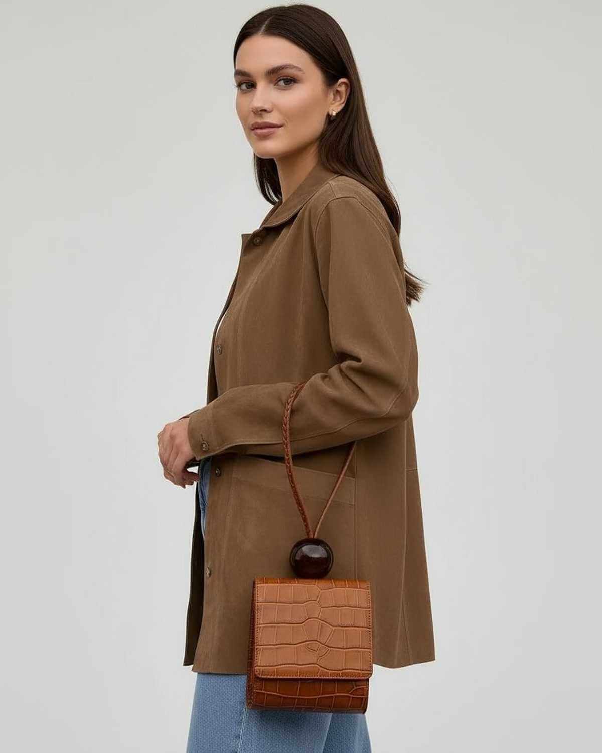 Model wearing Lola Jacket, a brown oversized piece perfect for all-season layering, paired with a chic handbag.