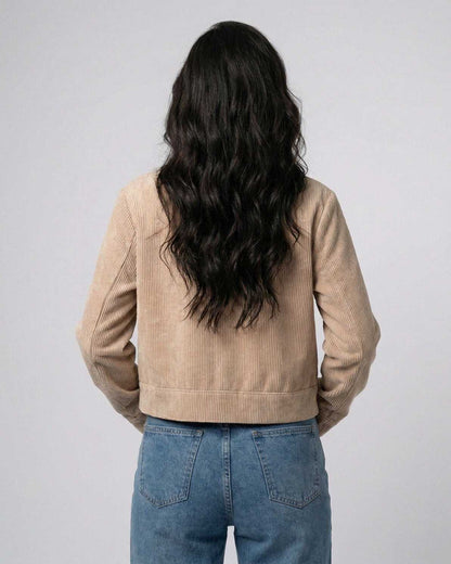 Back view of a woman wearing the Meva Jacket, a beige lightweight jacket from RAMBLION, ideal for everyday style.