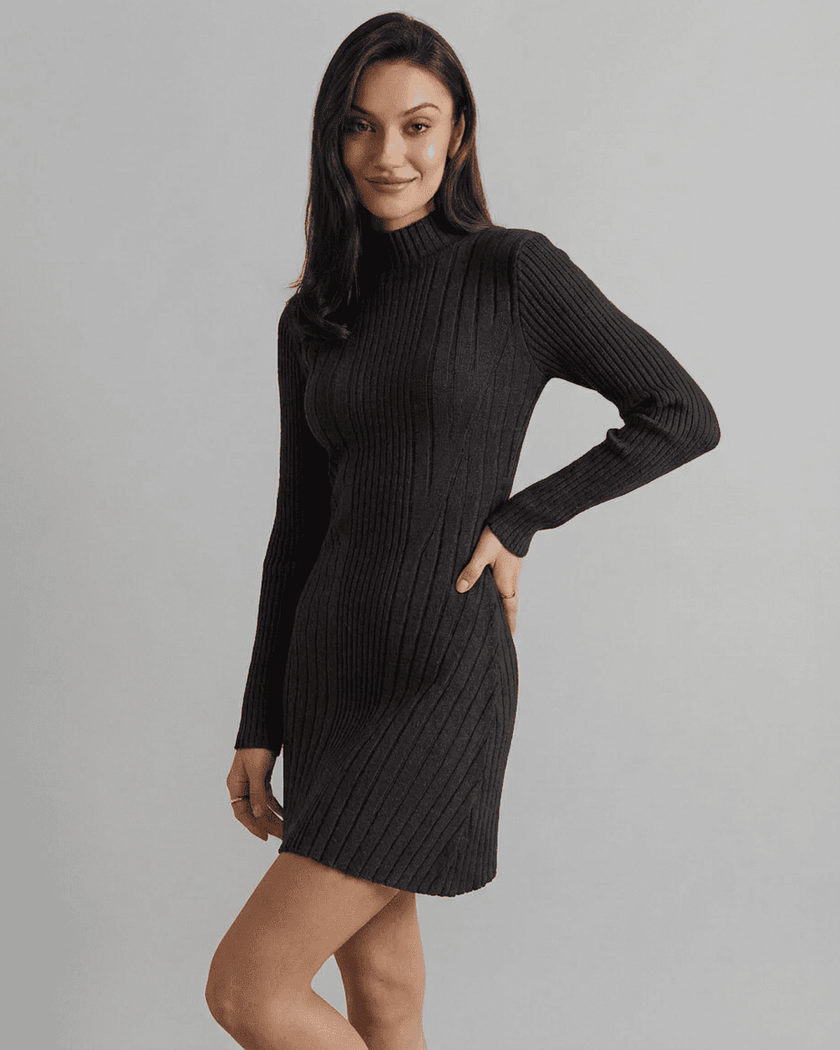 Milano Mini Dress modeled by a woman in a ribbed knit black mock neck design, showcasing a sleek A-line silhouette.