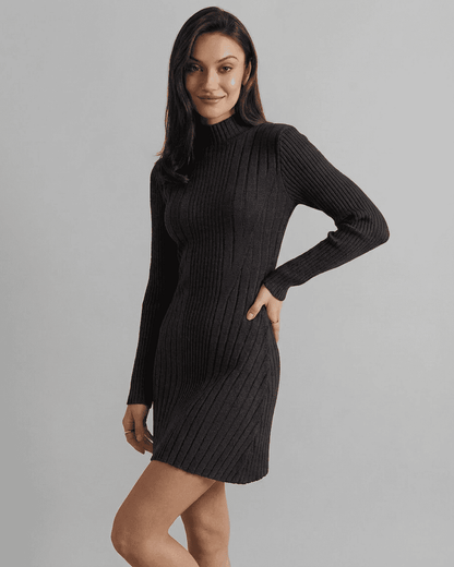 Milano Mini Dress modeled by a woman in a ribbed knit black mock neck design, showcasing a sleek A-line silhouette.