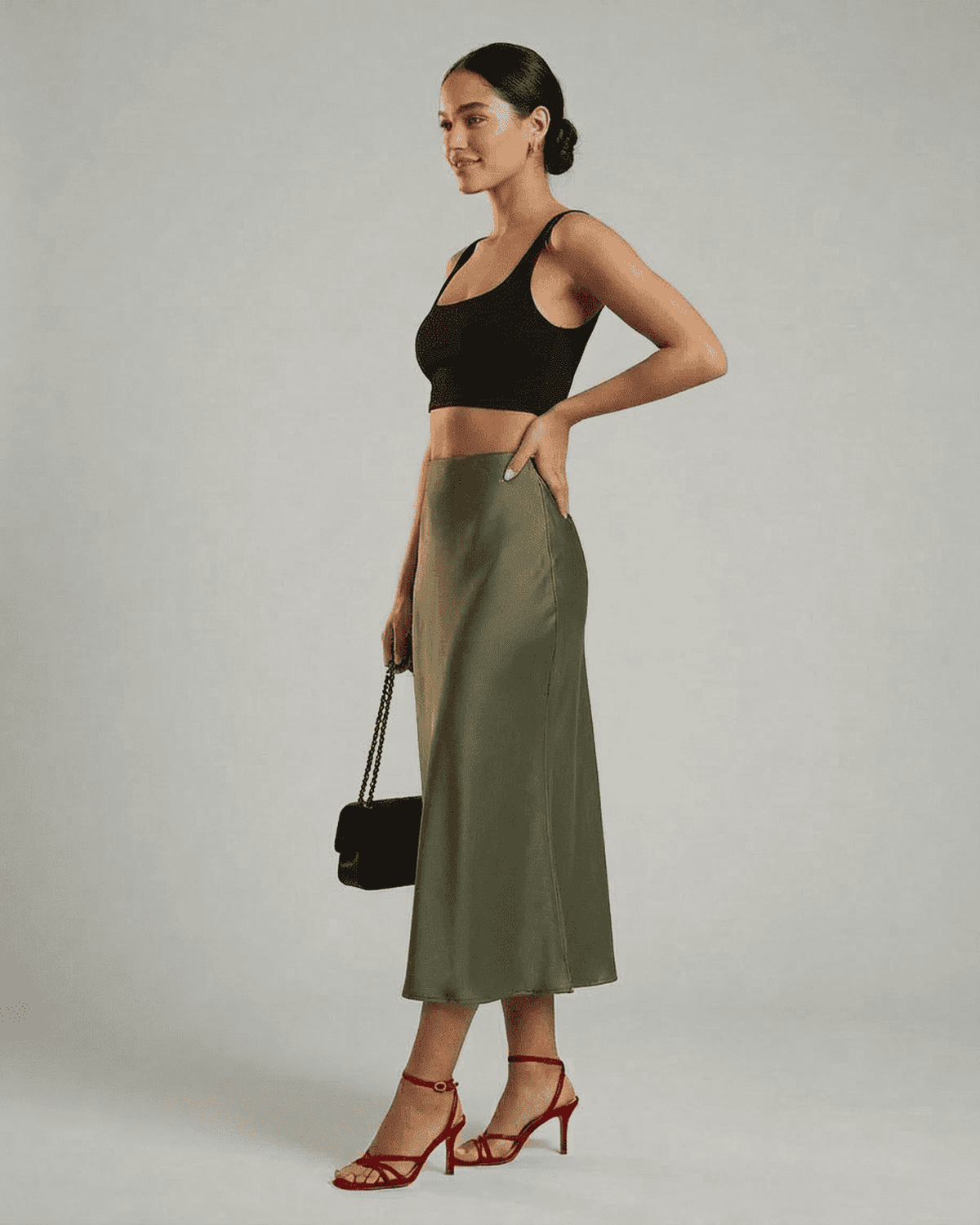 Model displaying the Olivia Midi Skirt by RAMBLION, featuring a satin mermaid silhouette in olive green.