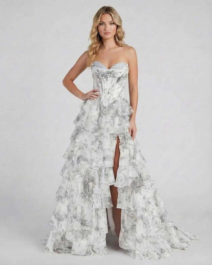 Ora Maxi Dress by RAMBLION, a luxurious strapless silver gown with tiered ruffles and a high slit, perfect for elegant occasions.