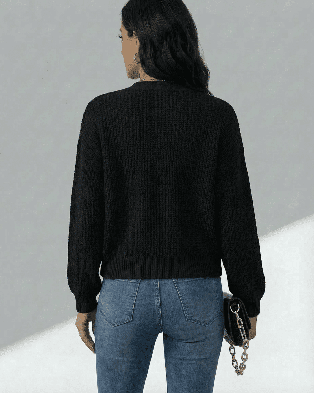Back view of a woman wearing the RAMBLION Orion Cardigan with long sleeves and jeans.