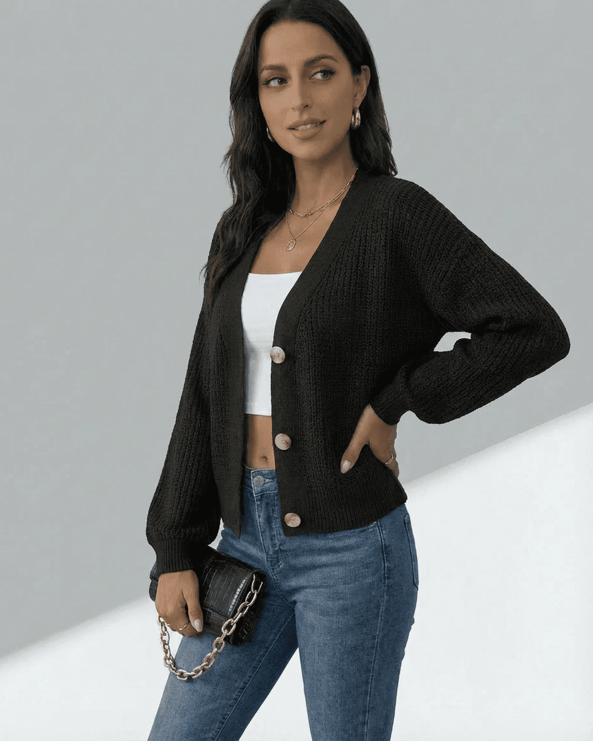 Model wearing an Orion Cardigan with a V-neckline, paired with a white tank and jeans, showcasing modern style.