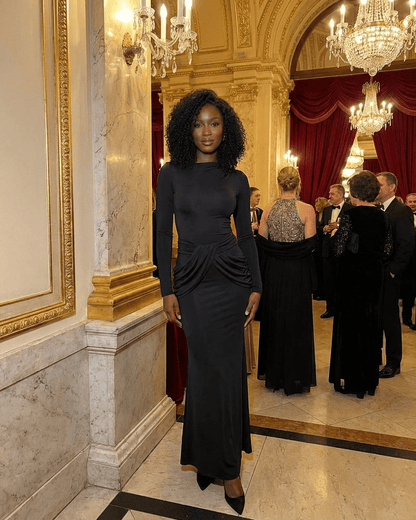 Orion Maxi Dress by RAMBLION, showcasing long sleeve crew neck silhouette with ruched high waist detail in elegant setting.