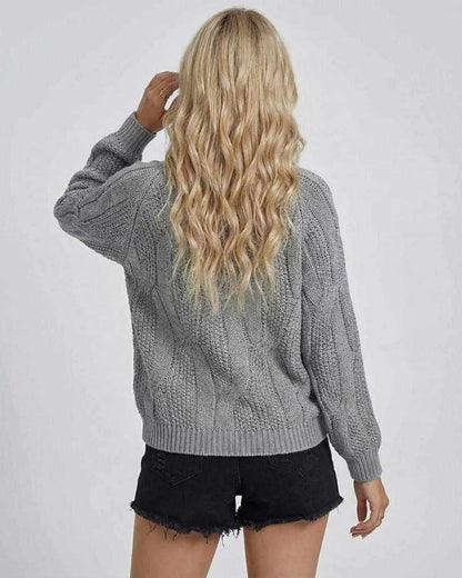 Back view of a woman wearing the RAMBLION Orion Sweater, showcasing its cable-knit design and relaxed fit.