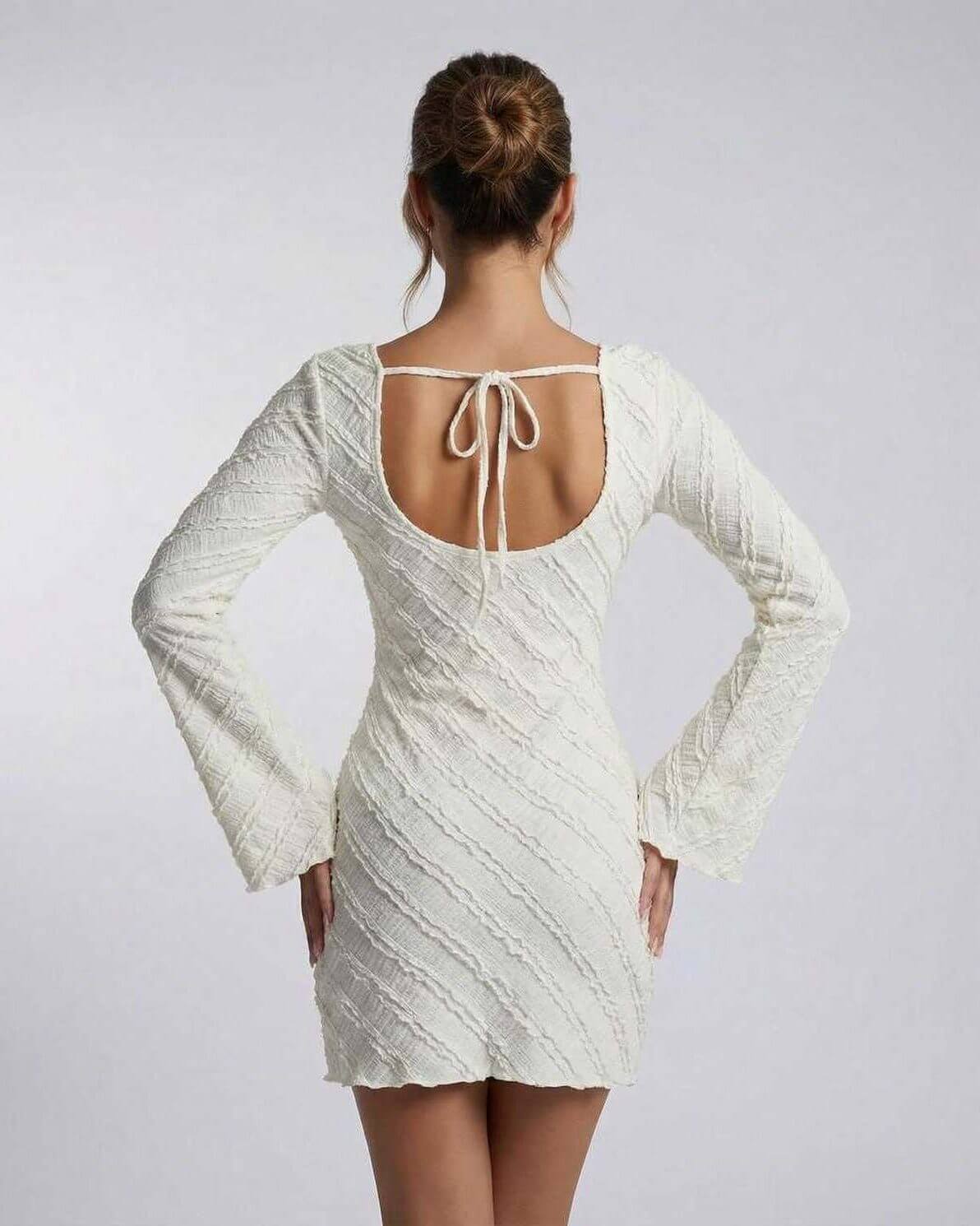 Back view of the Pearlescent Mini Dress by RAMBLION, featuring long bell sleeves and tie detail, perfect for formal occasions.