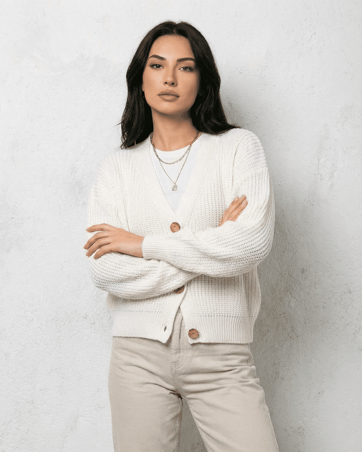Alba Cardigan by RAMBLION displayed on model in white knitwear with soft V-neck design.