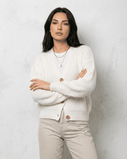 Alba Cardigan by RAMBLION displayed on model in white knitwear with soft V-neck design.