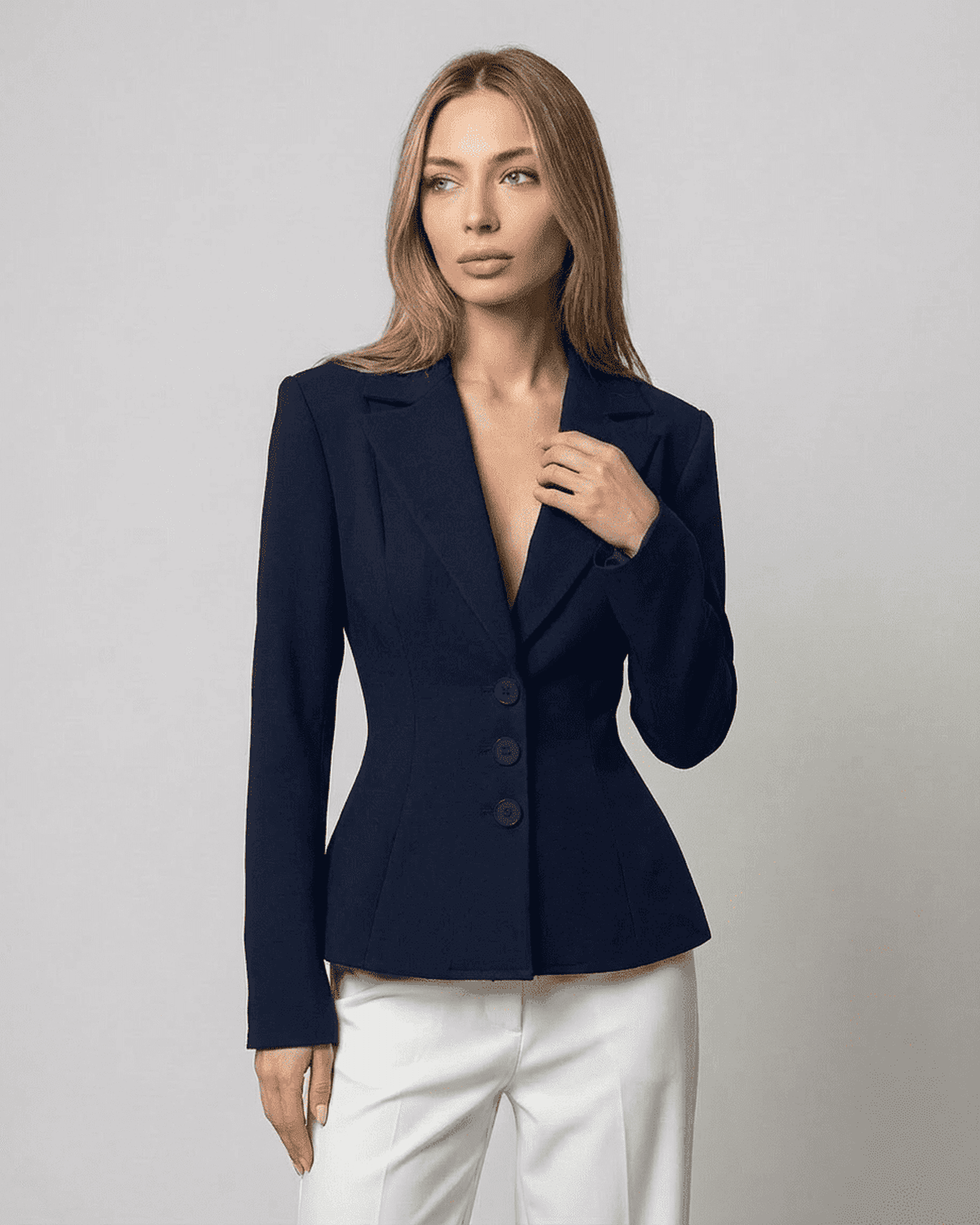 A model wearing the stylish Aurora Blazer by RAMBLION, featuring a fitted waist and V-neckline.