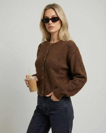 Cocoa Cardigan worn by a woman holding a drink, showcasing its button-front design and relaxed fit.