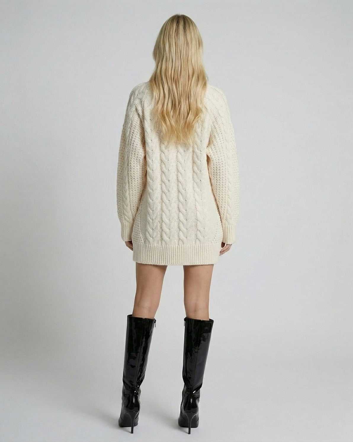 Back view of a model wearing the Eira Sweater by RAMBLION, featuring a cable-knit design and long sleeves.