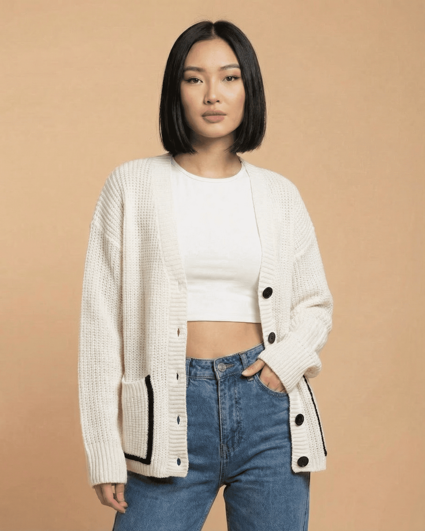 Elara Cardigan by RAMBLION worn by a model, featuring a loose fit, v-neck, and color block knit design.