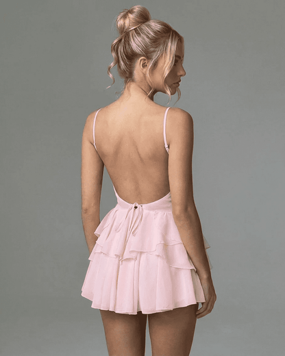 Isolde Mini Dress by RAMBLION, showcasing a back view with spaghetti straps and layered ruffle skirt in soft pink.