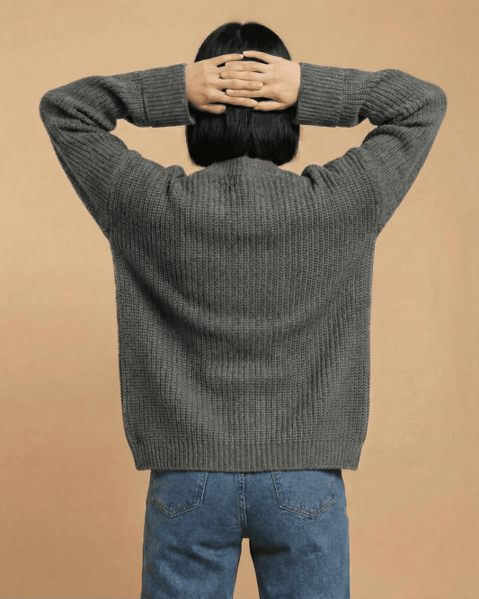 Back view of a model wearing the Linden Cardigan in gray, showcasing its relaxed fit and cozy design.