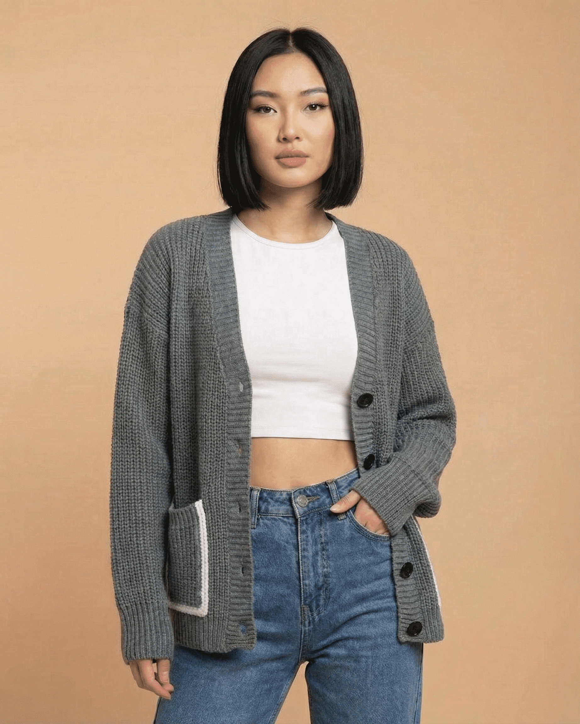 Linden Cardigan in gray worn by a model, featuring a relaxed V-neck design and button-front closure.