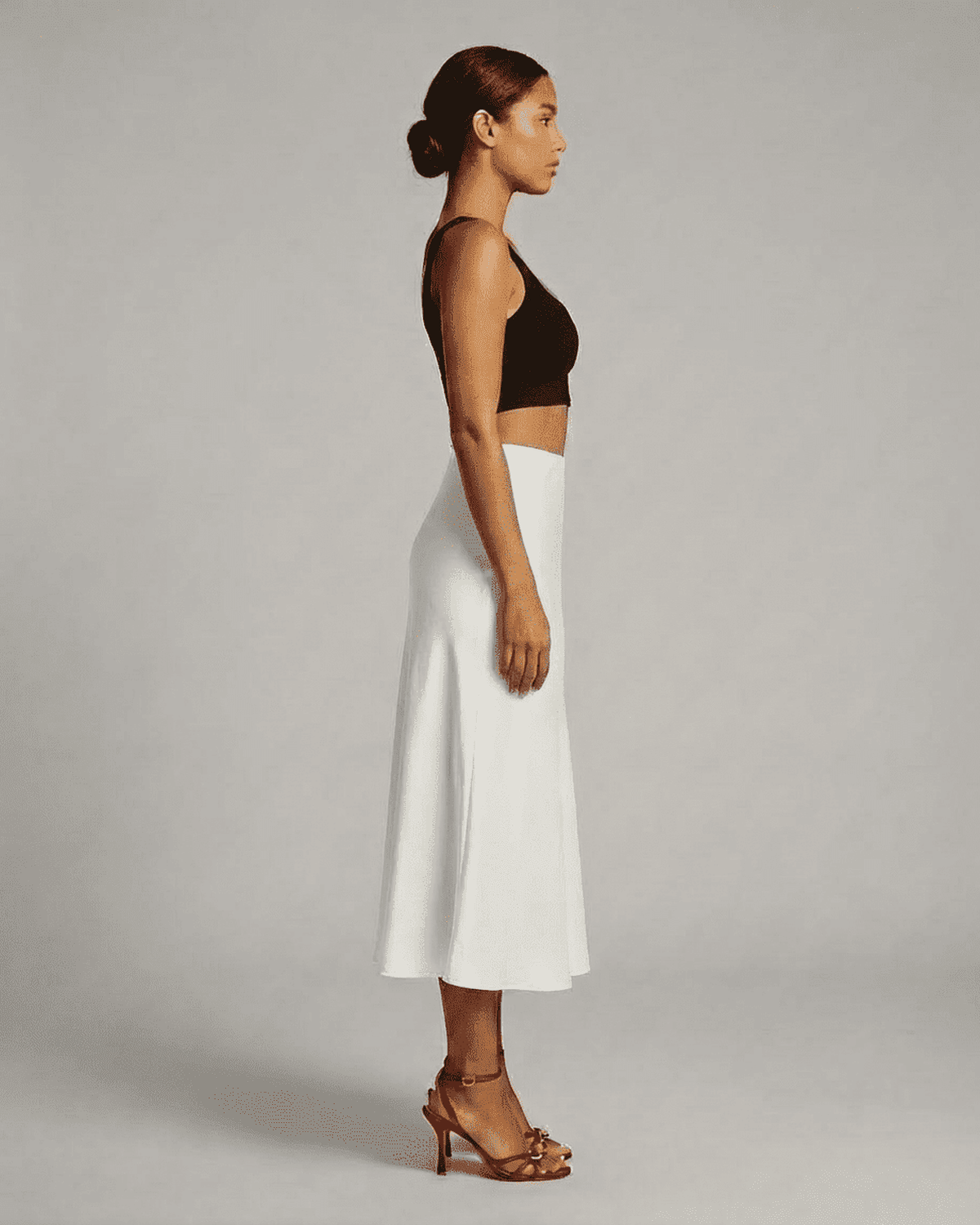 Side view of a model wearing the Luna Midi Skirt, a satin mermaid midi skirt by RAMBLION, showcasing elegant design.