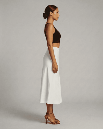 Side view of a model wearing the Luna Midi Skirt, a satin mermaid midi skirt by RAMBLION, showcasing elegant design.