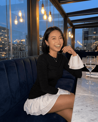 Luna Mini Dress styled with flared sleeves and a stylish black and white color block design.