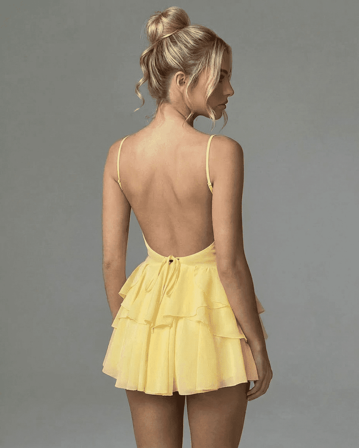 Marigold Mini Dress featuring a backless design with adjustable spaghetti straps and tiered ruffle skirt.