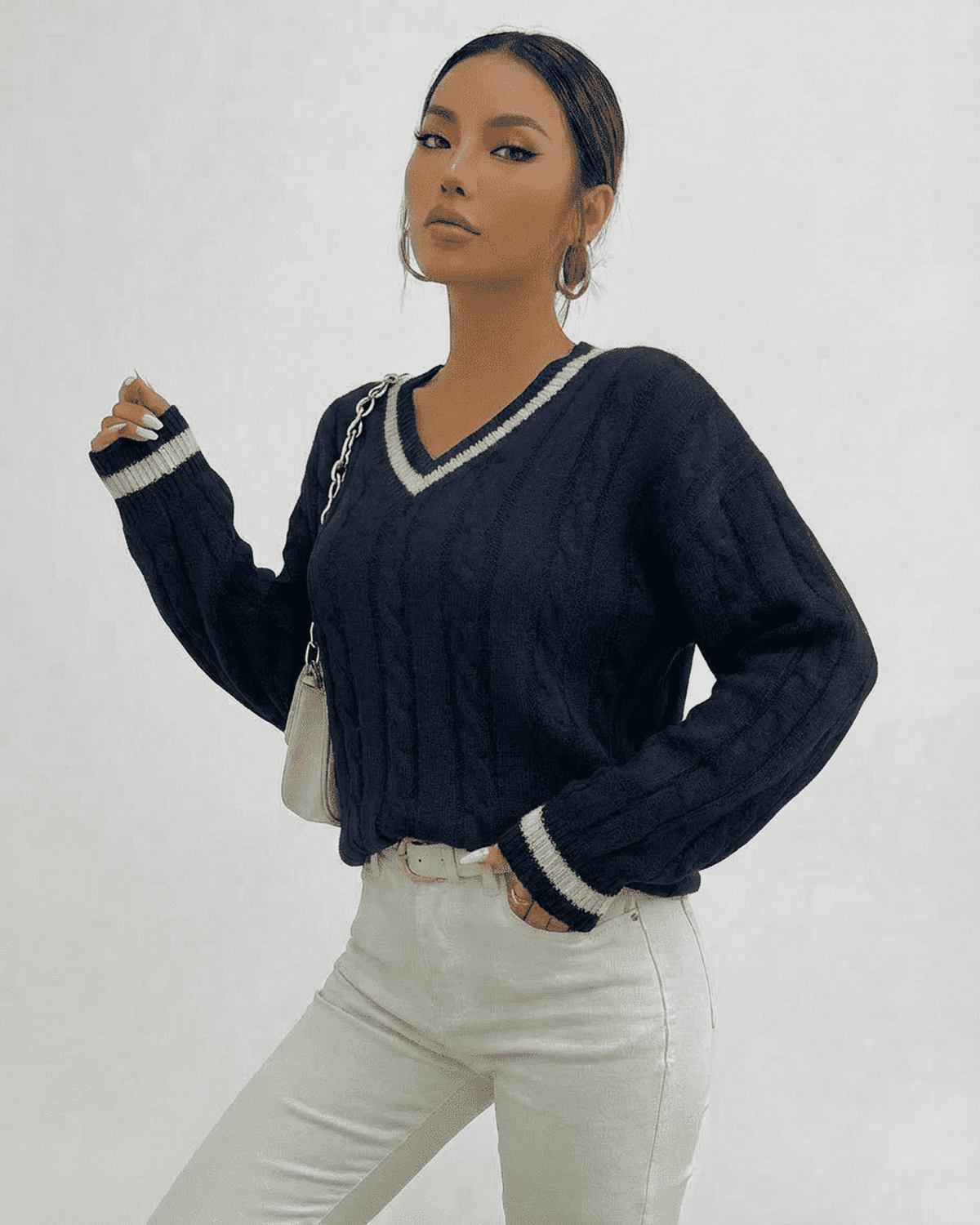 Marina Sweater – Cable Knit V-Neck Pullover in navy worn with white jeans, showcasing a stylish look by RAMBLION.
