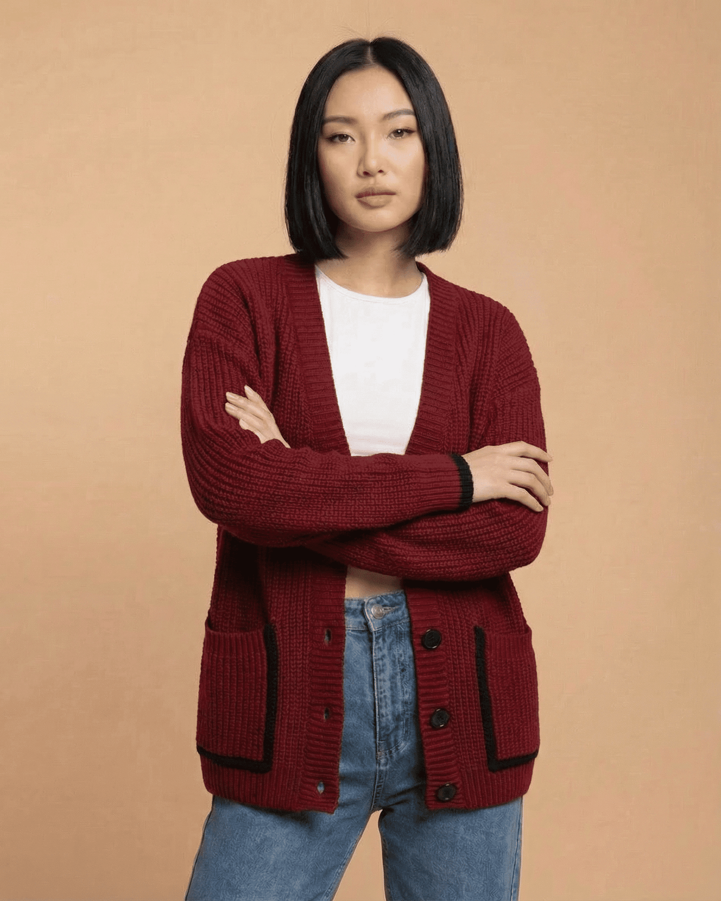 Model wearing the Merano Cardigan by RAMBLION in red, featuring a loose fit and button-front design.